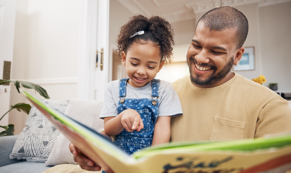 Une jeune fille regarde des livres avec son papa